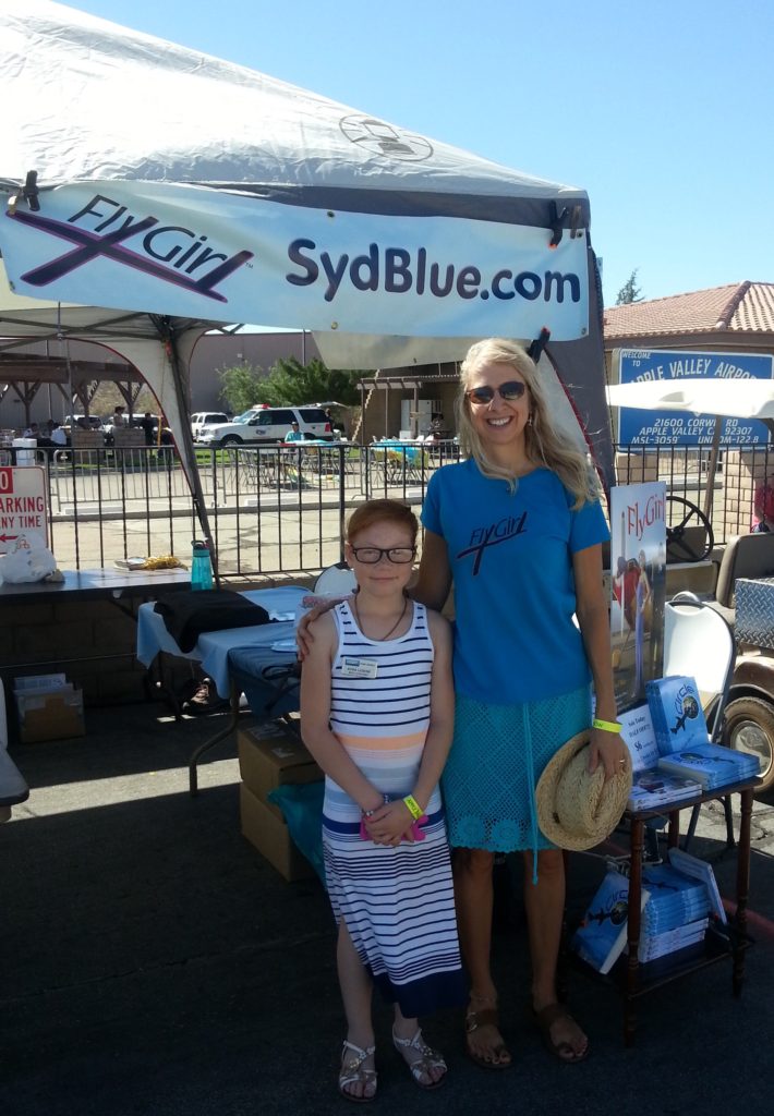 This girl at the Apple Valley airshow would rather read about flying than go up in the sky. lol